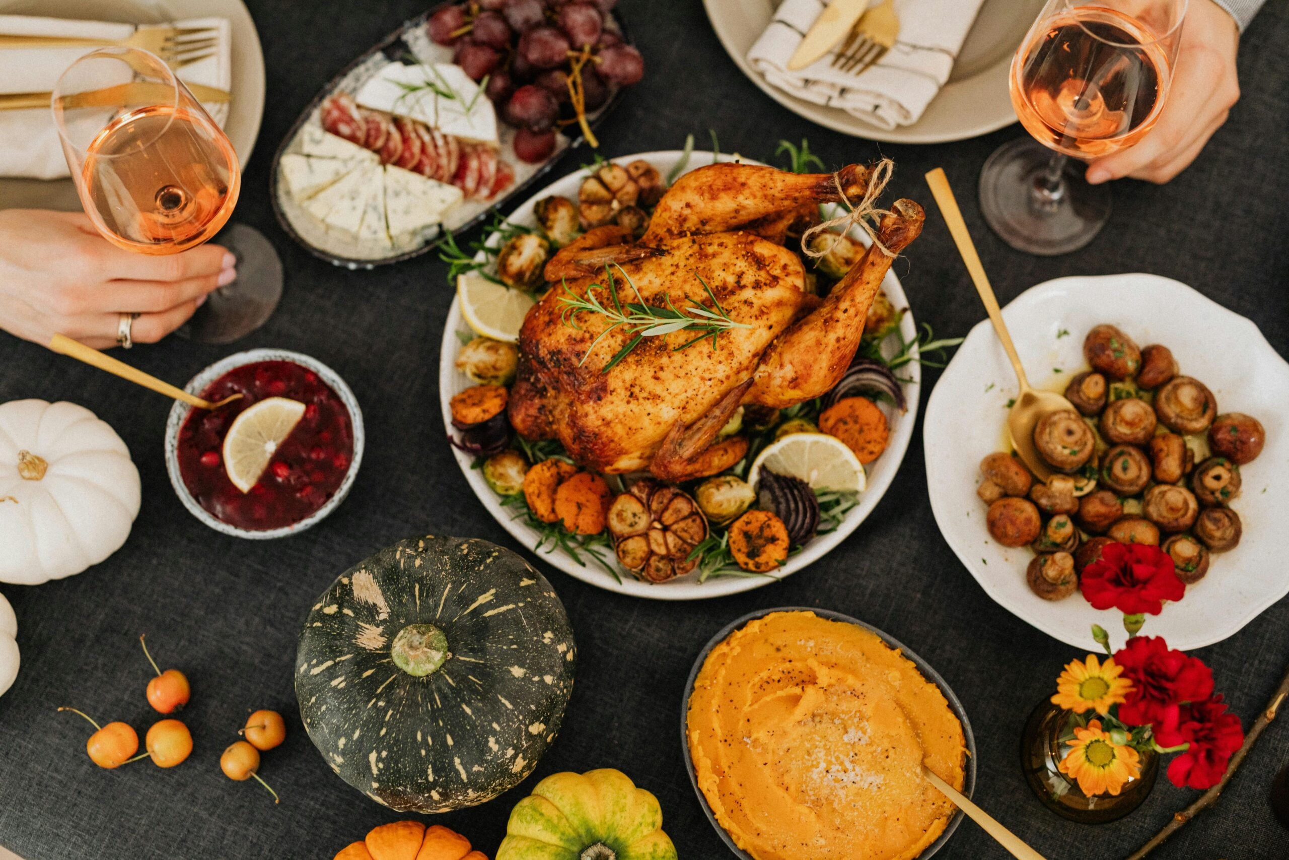 A delicious Thanksgiving feast featuring roasted chicken, wine, and seasonal sides. Top view.