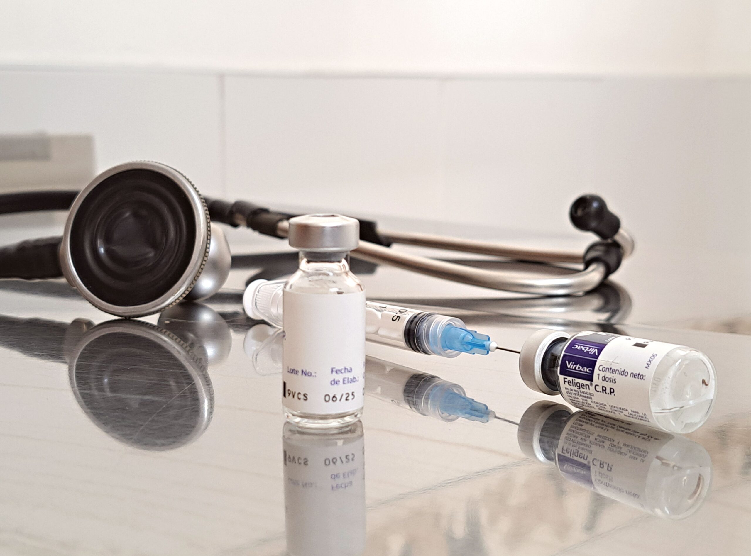 Stethoscope, medication vial, and syringe on a clinic counter, representing physician-supervised medical weight loss treatment.